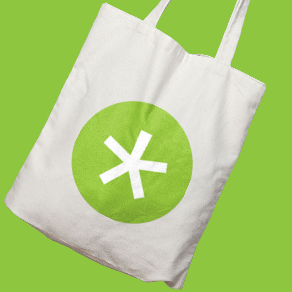 white tote bag with green circle and white asterix, esc productions branded