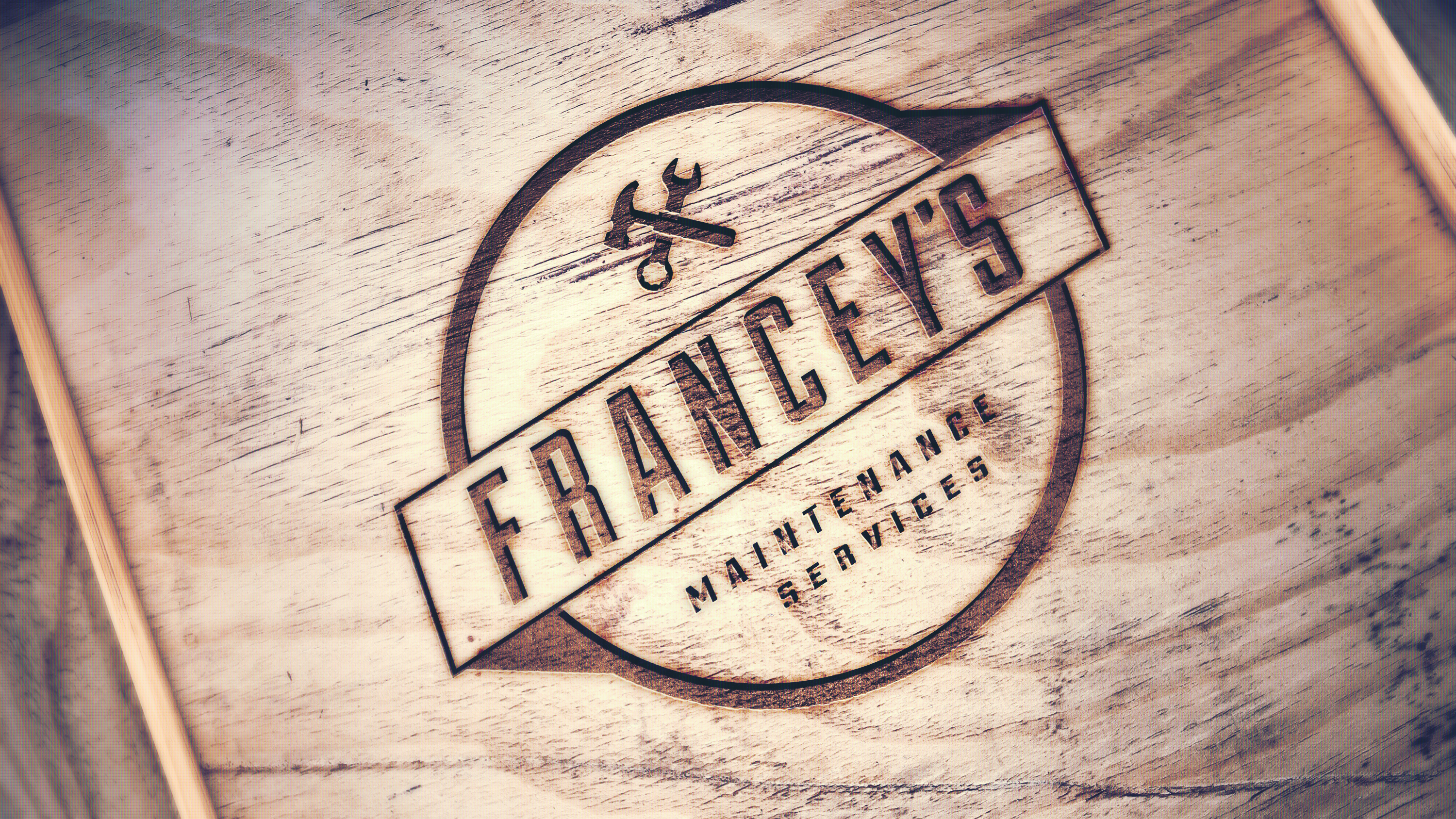 Wood burn of Francey's Maintenance services logo with hammer and spanner