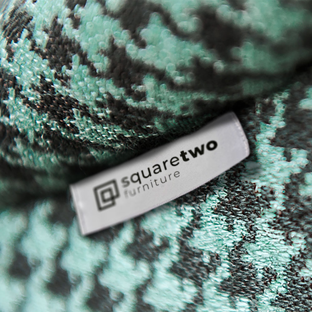 Close up of mint green and black sofa detail with Square Two Furniture on label